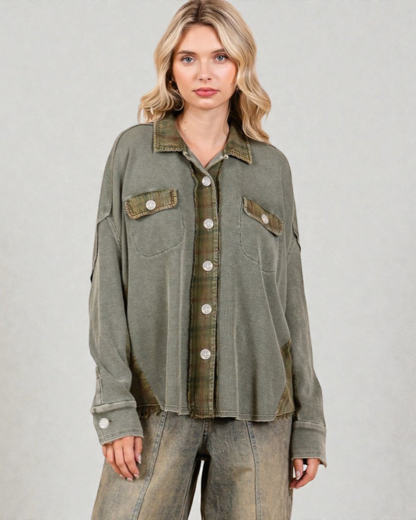 Woman wearing a green jacket with button details on a plain background