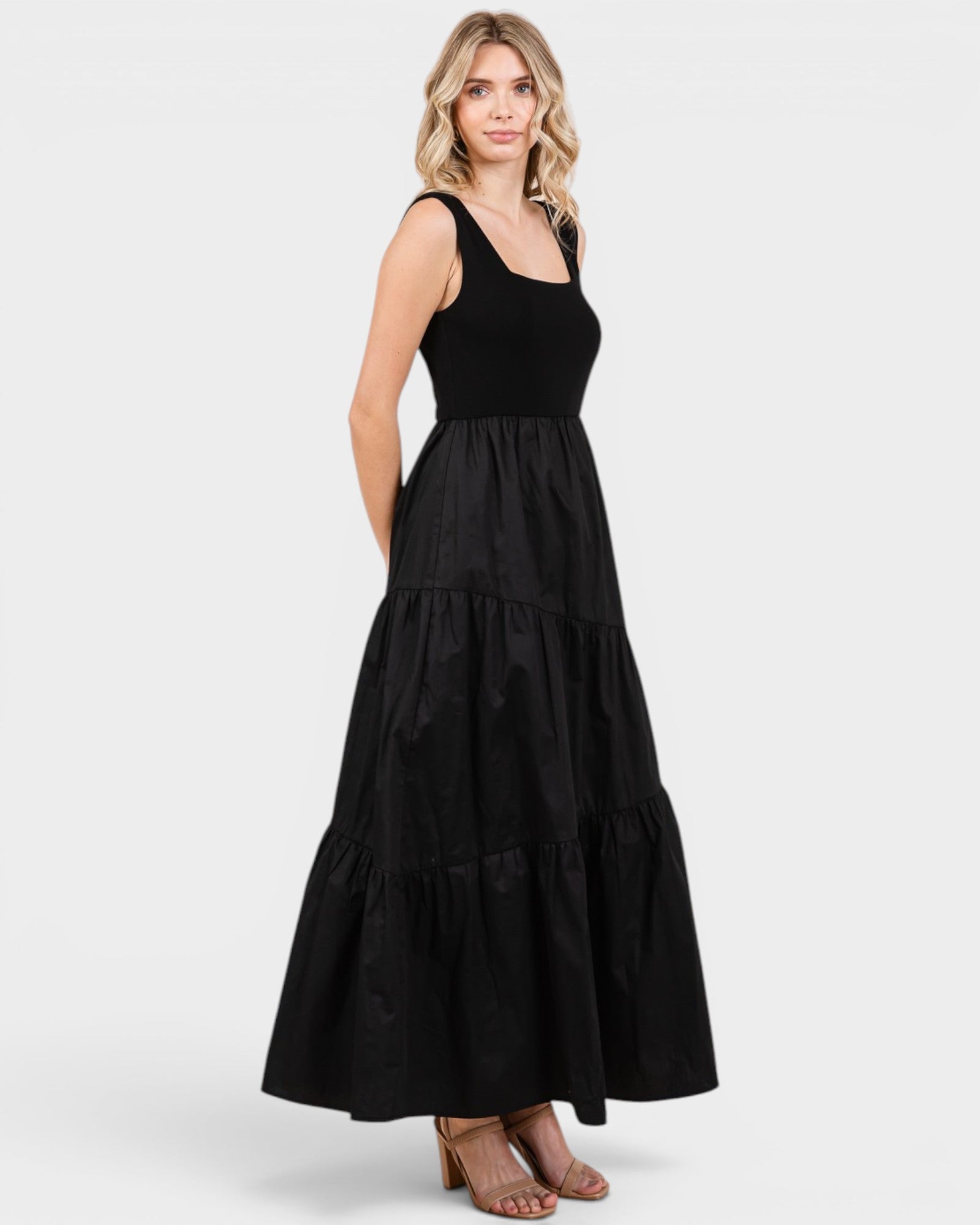 Woman wearing a black tiered dress on a white background