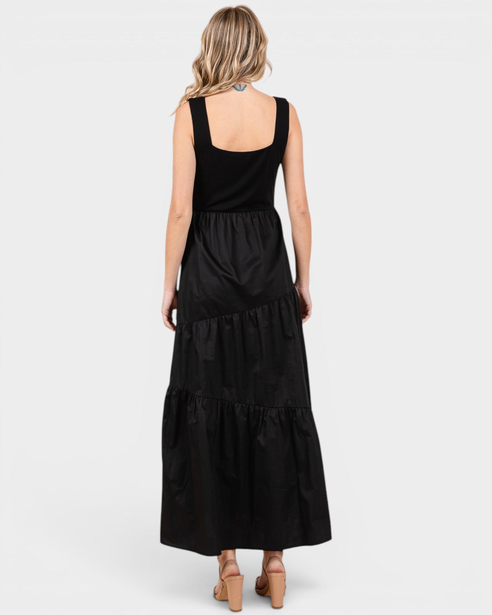 Woman wearing a black tiered dress on a white background