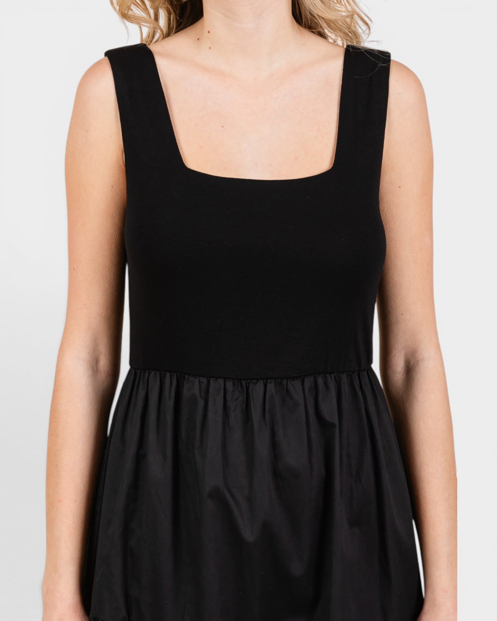 Black sleeveless dress on a plain background