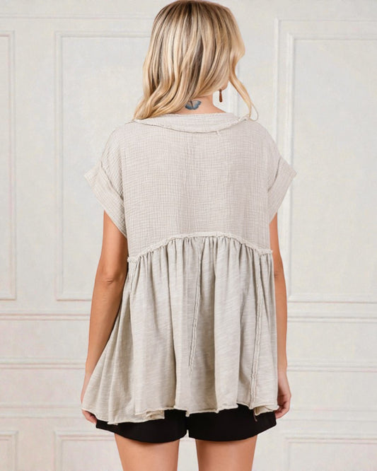 Woman wearing a beige short-sleeve top with a white background