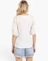 A woman shown from the back wearing a white textured top with lace puff sleeves and light blue denim shorts against a plain white background.