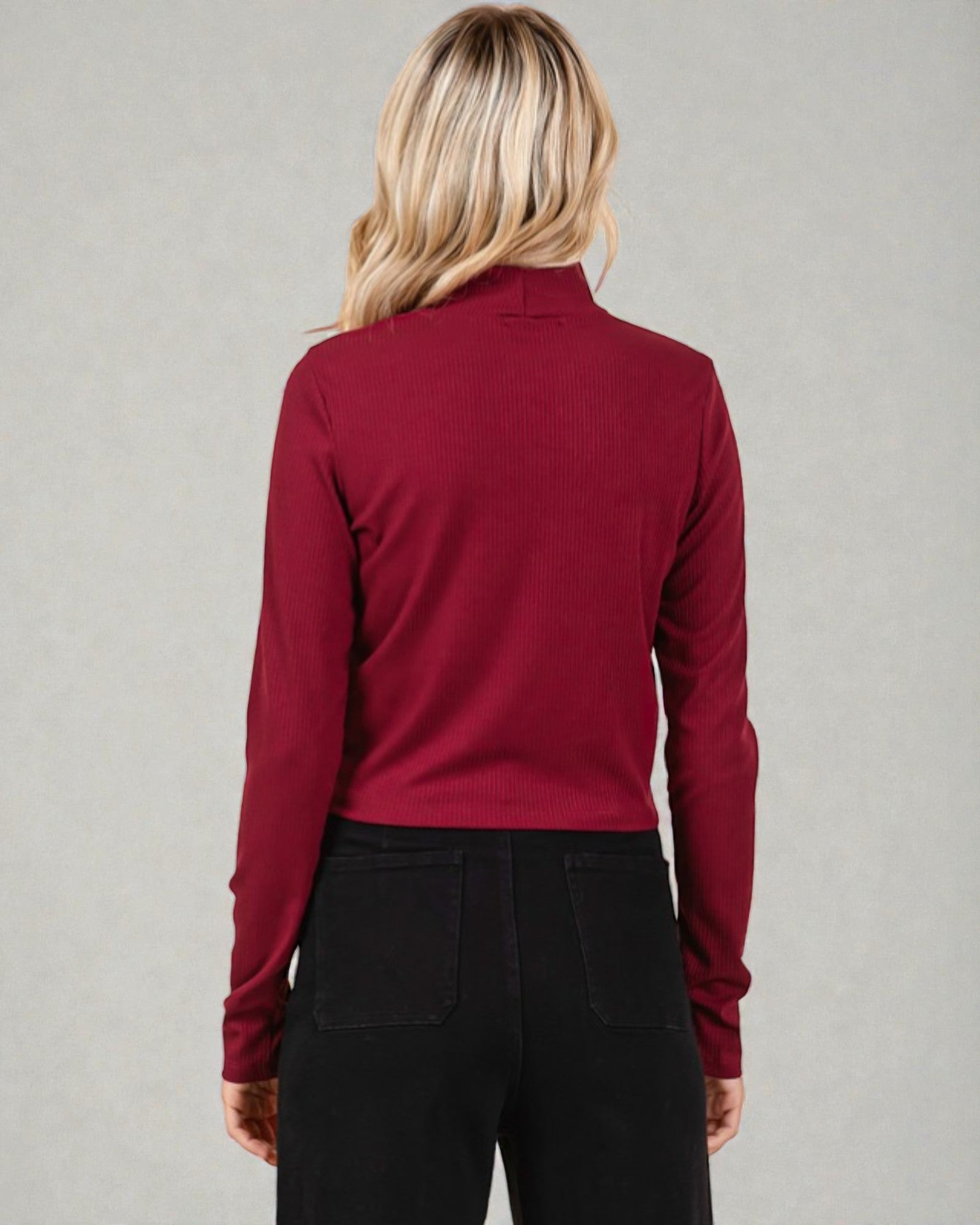 Person wearing a red long-sleeve shirt against a gray background