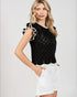 Woman wearing a black and white patterned top with a plain background