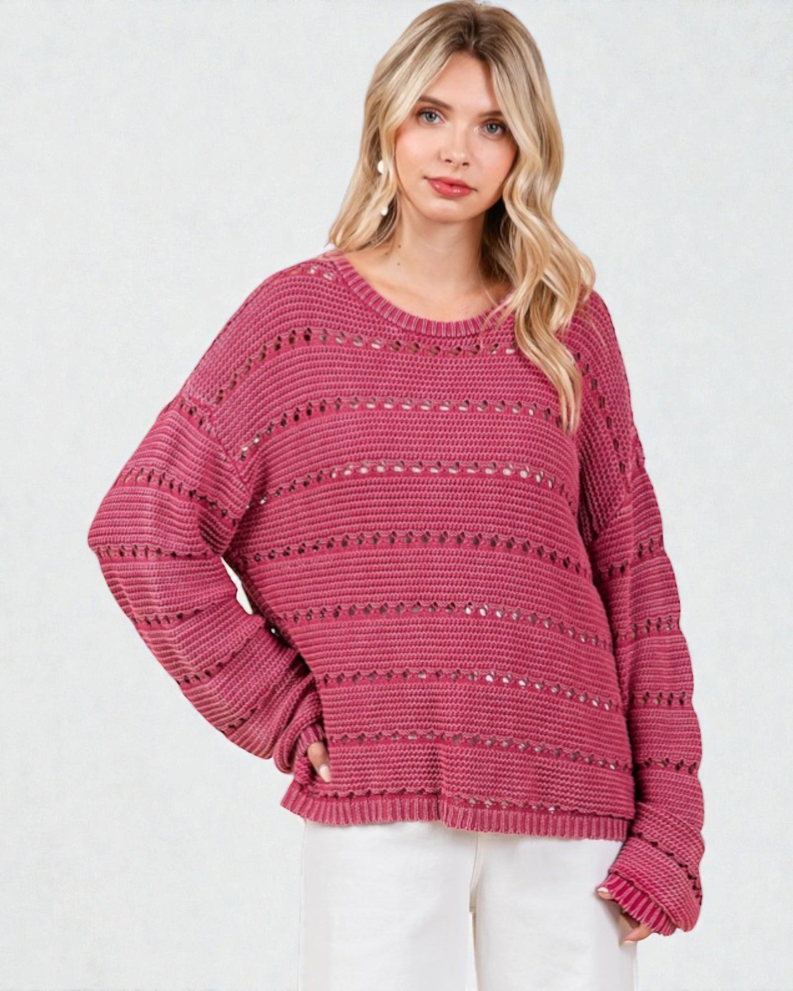 Woman wearing a pink sweater with a white background