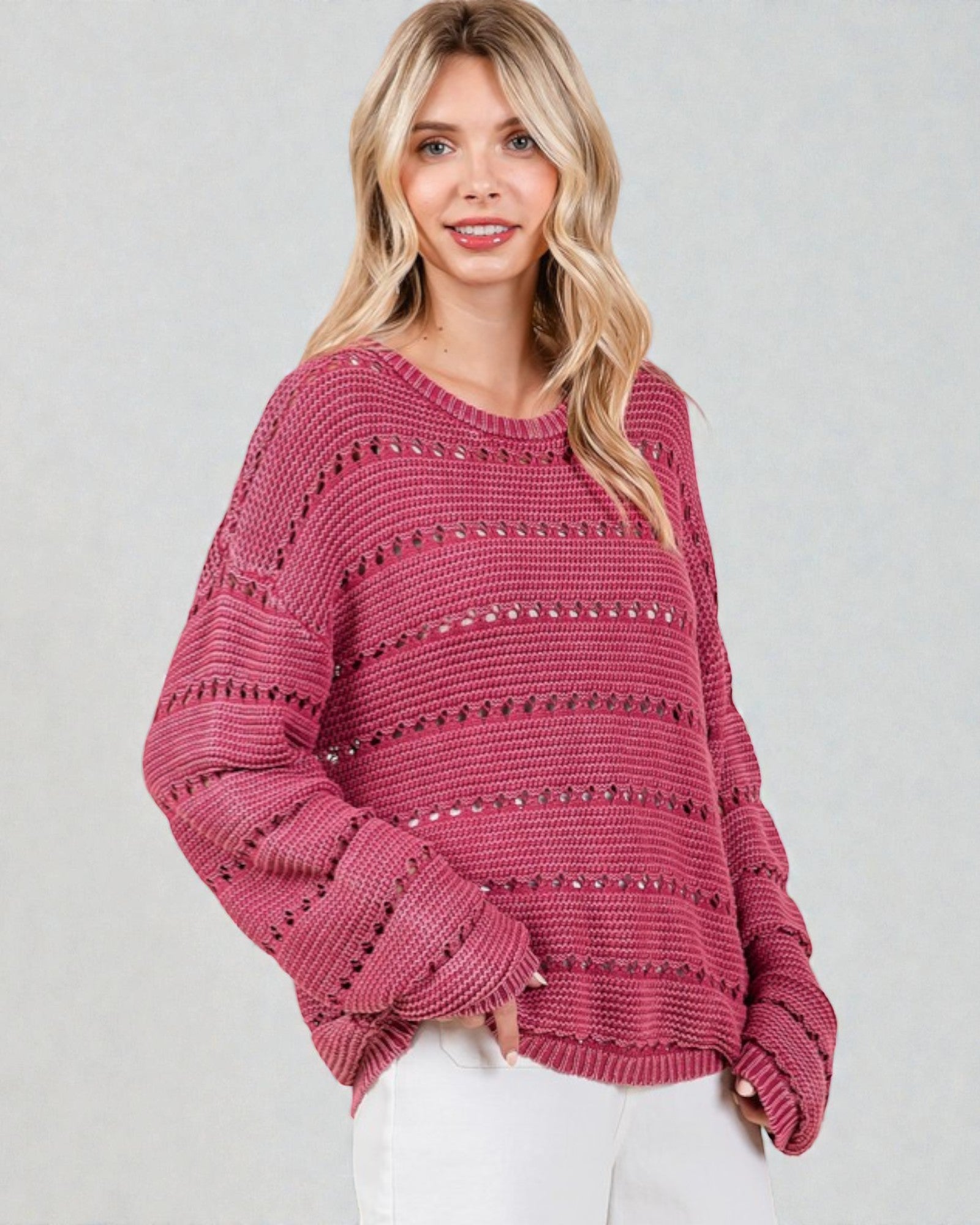 Woman wearing a pink sweater against a plain background