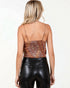 Person wearing a metallic top and black leather pants on a white background