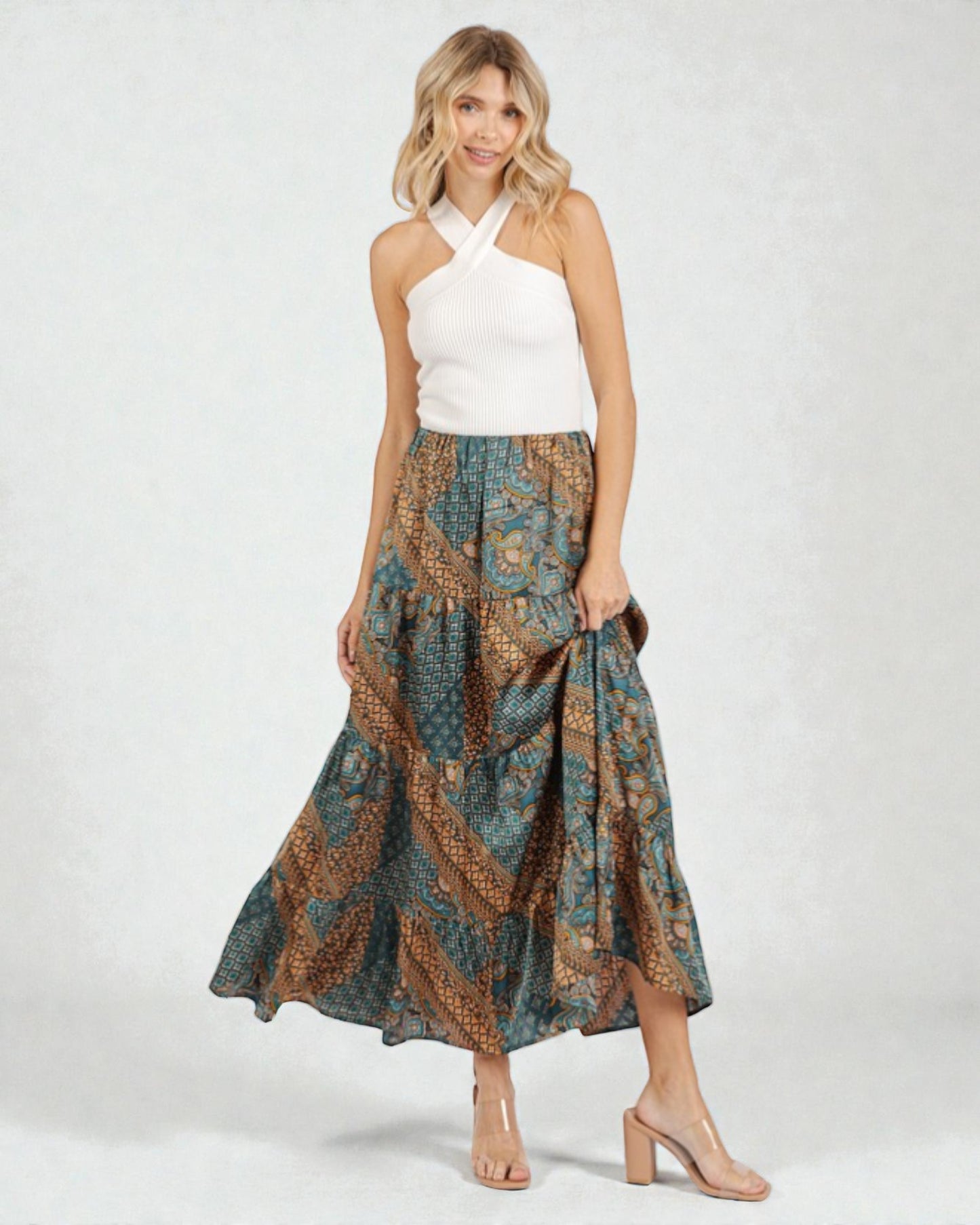 Woman wearing a white top and patterned skirt on a white background