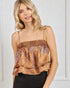 Woman wearing a patterned top against a white wall