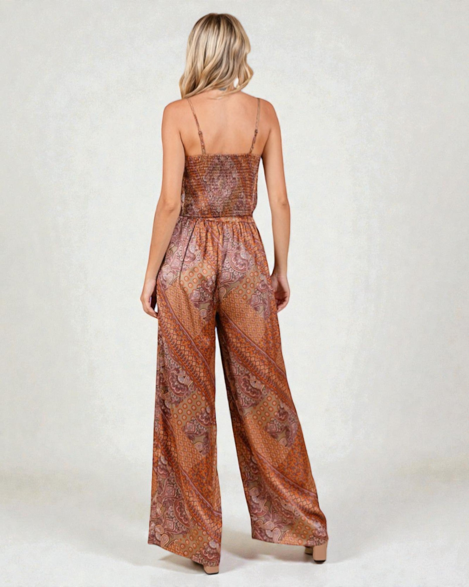 Woman wearing a patterned jumpsuit on a white background
