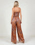 Woman wearing a patterned jumpsuit on a white background