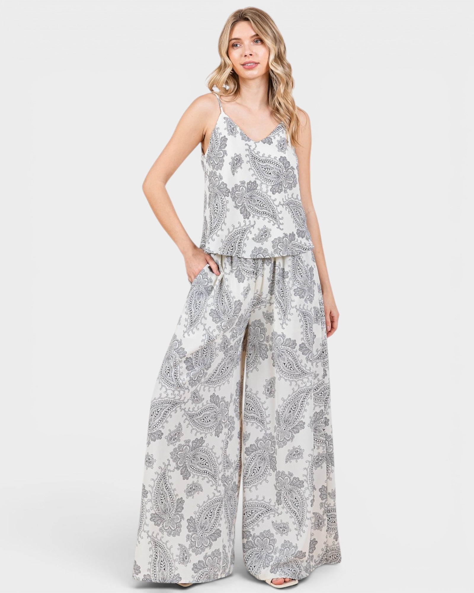 Woman wearing a gray and white patterned jumpsuit on a white background