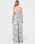 Woman wearing a white floral patterned jumpsuit on a white background