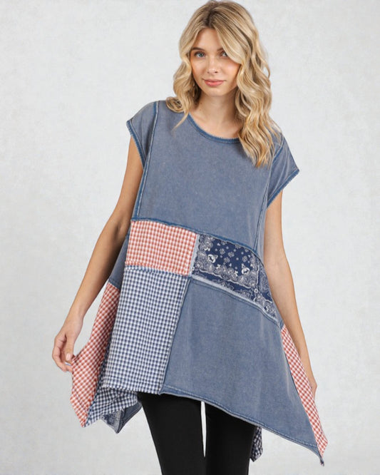 Woman wearing a patchwork dress with various patterns on a plain background