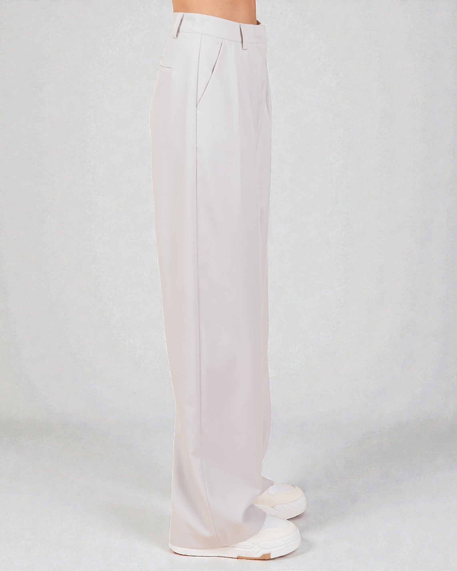 White pants worn by a person on a light gray background
