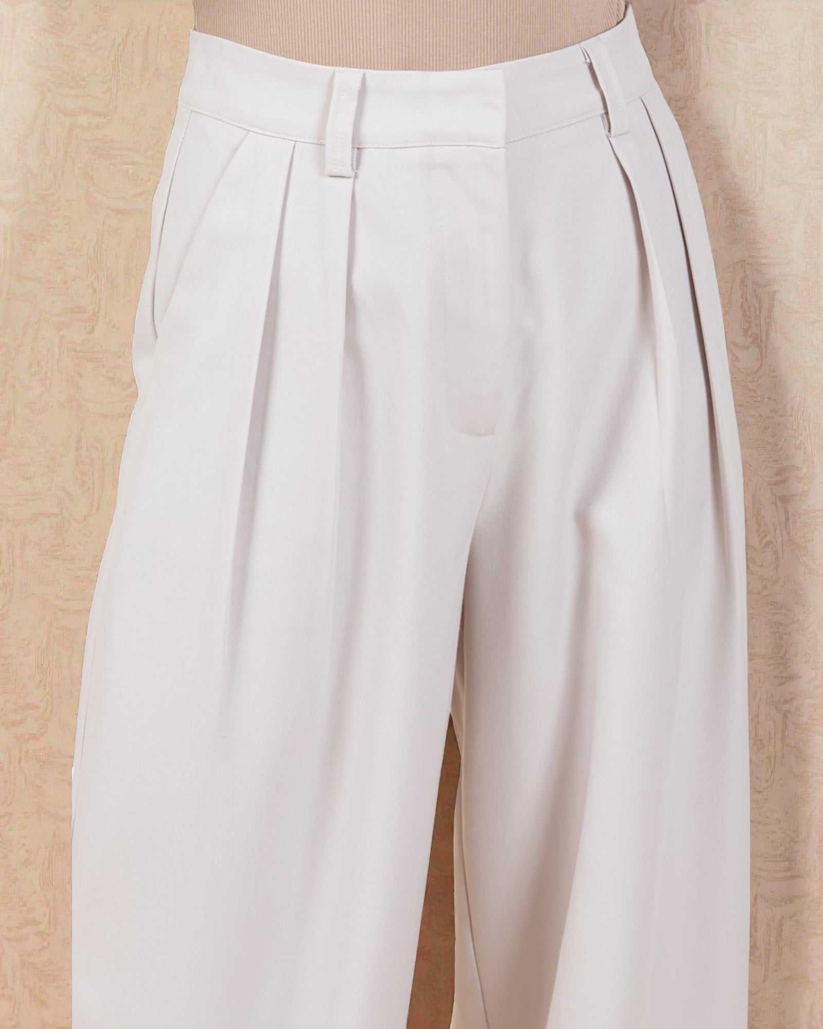 White pleated pants on a beige background