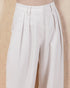 White pleated pants on a beige background