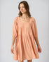 Woman wearing a peach-colored dress on a plain background
