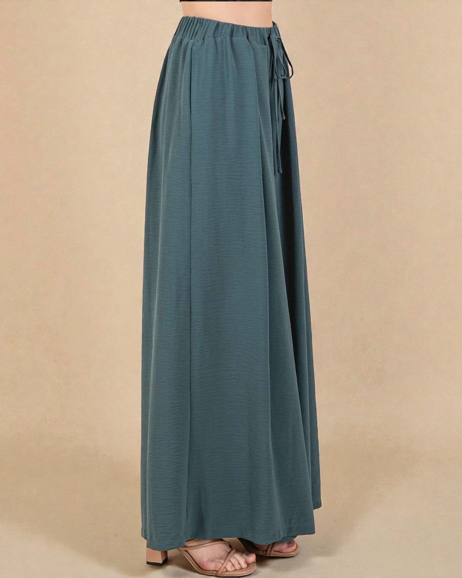 Teal wide-leg pants on a beige background