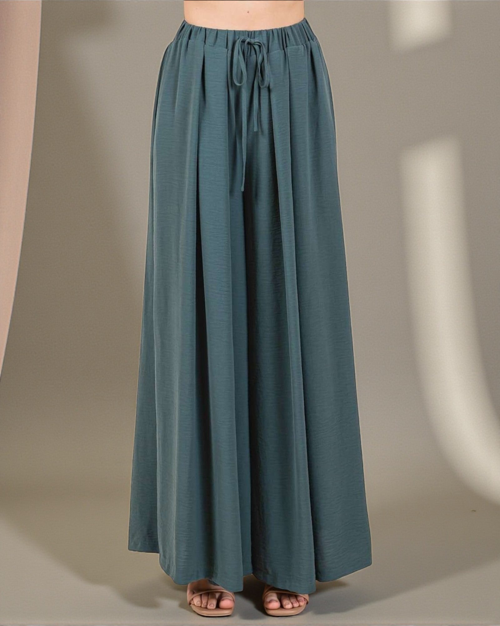 Teal wide-leg pants on a neutral background
