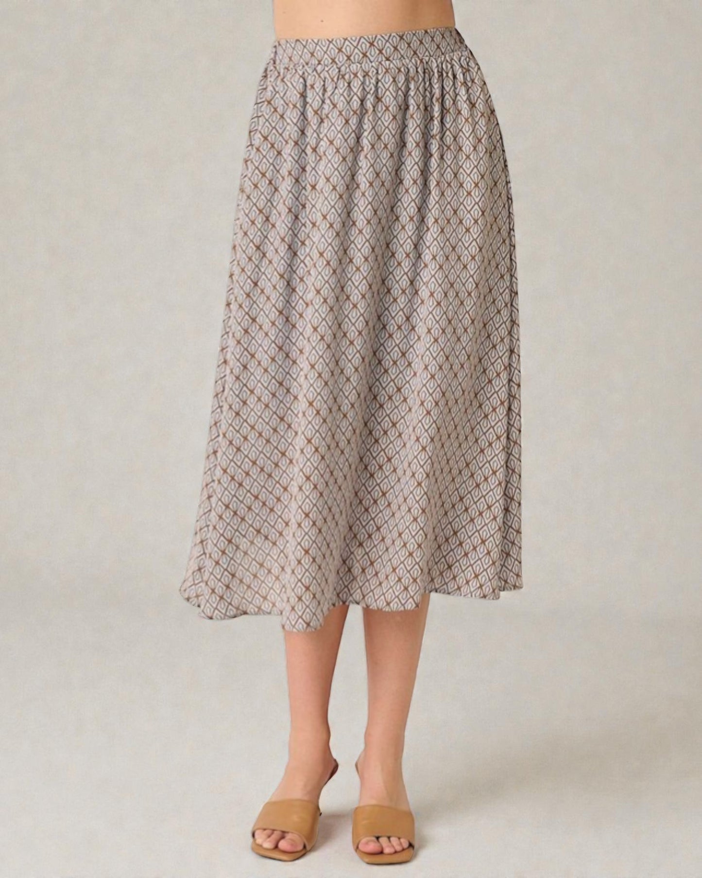 Person wearing a patterned skirt on a plain background