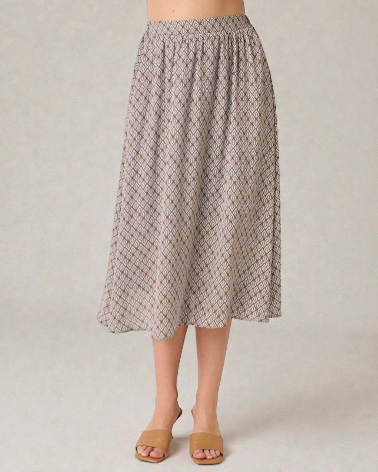 Person wearing a patterned skirt on a plain background