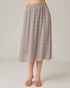 Person wearing a patterned skirt on a plain background