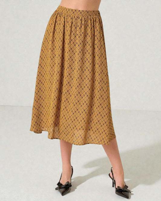 Person wearing a patterned mustard yellow skirt on a white background