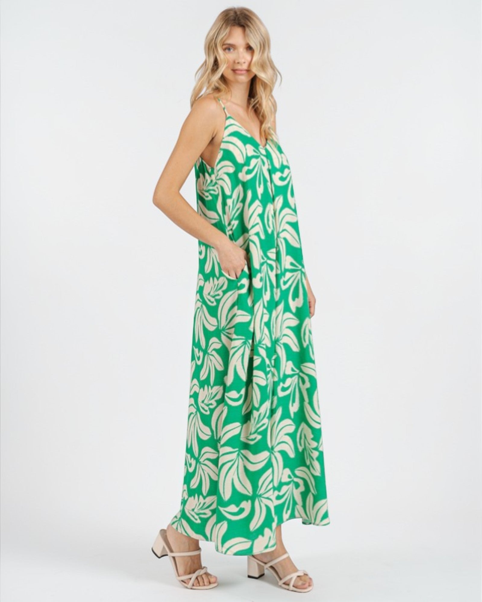 Woman wearing a green and white leaf-patterned dress on a white background