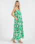 Woman wearing a green and white leaf-patterned dress on a white background