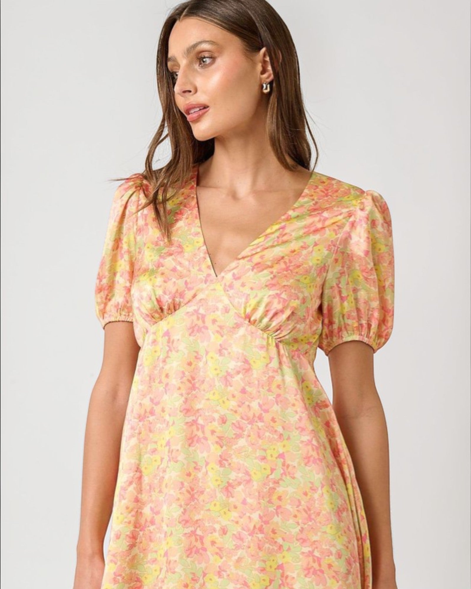 Woman wearing a floral dress on a plain background