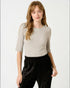Woman wearing a gray sweater and black pants on a white background