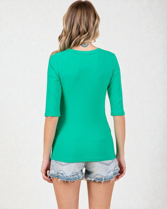 Woman wearing a green top and denim shorts on a white background