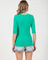Woman wearing a green top and denim shorts on a white background