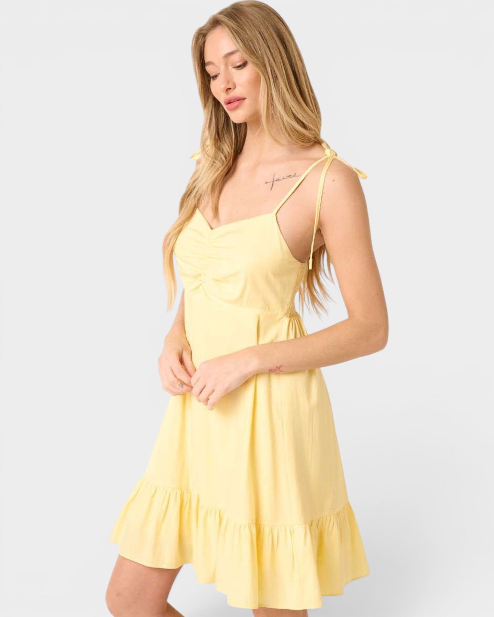 Woman wearing a yellow dress against a white background
