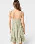 Woman wearing a light green dress with thin straps on a white background