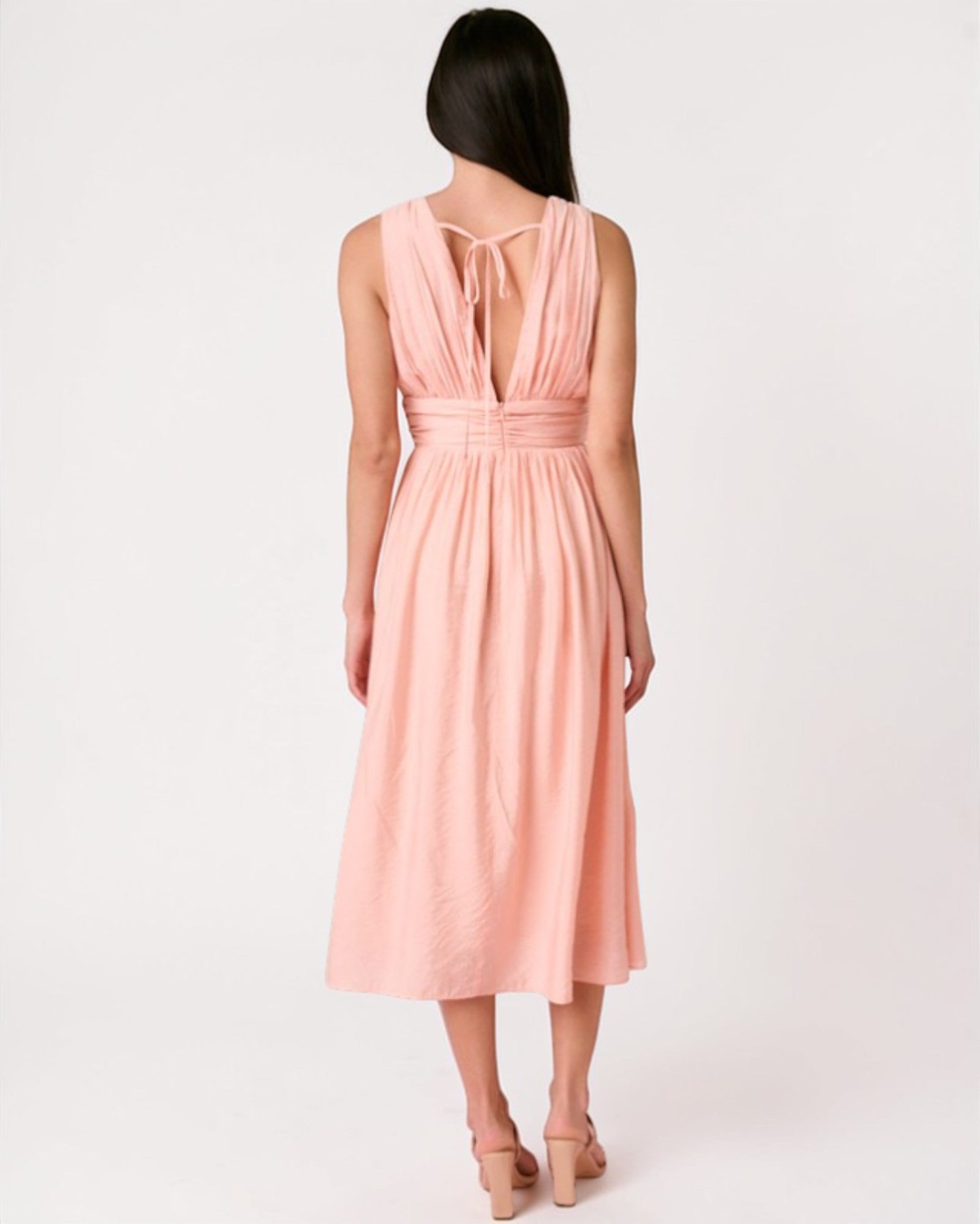 Woman wearing a pink dress with a white background