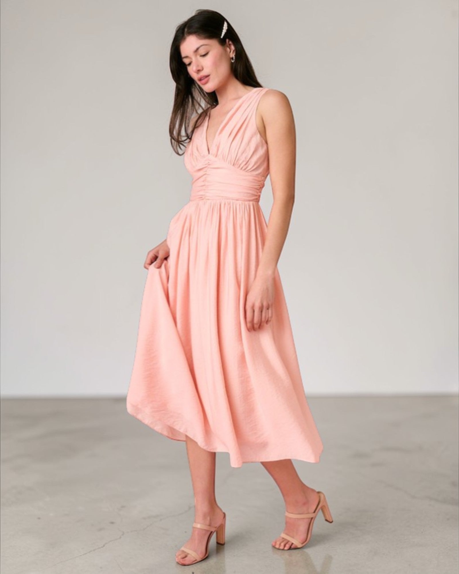 Woman wearing a pink dress against a plain background