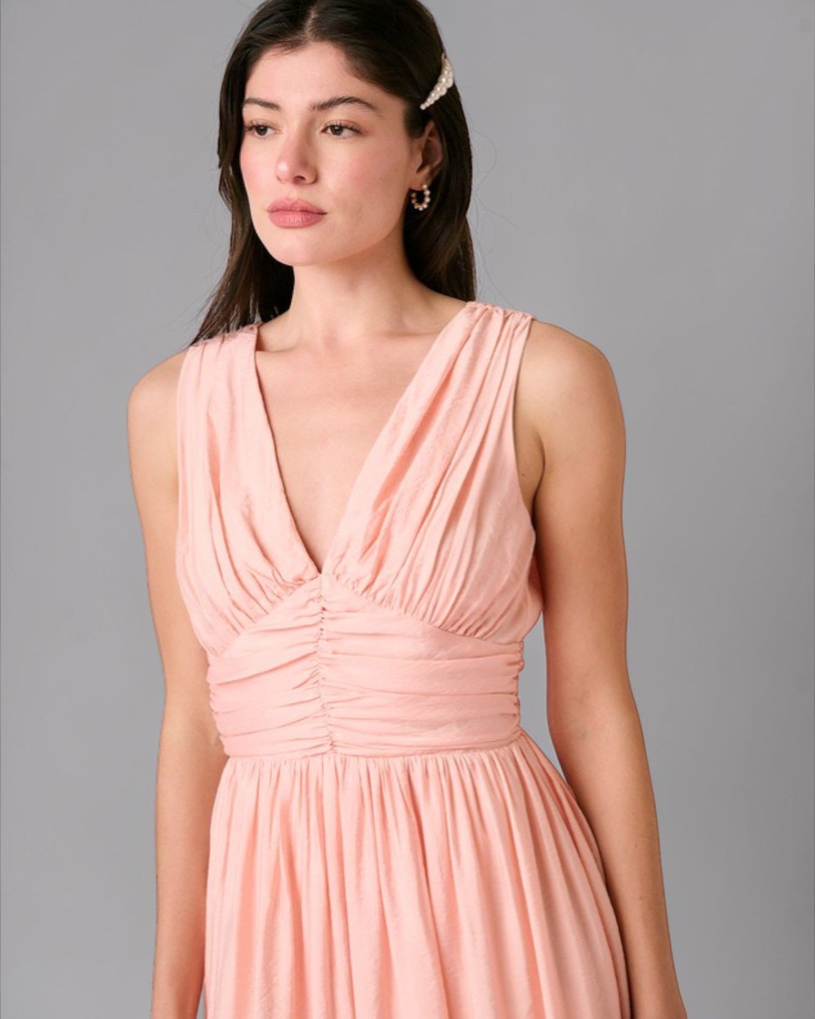 Woman wearing a pink dress against a gray background