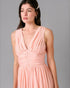 Woman wearing a pink dress against a gray background