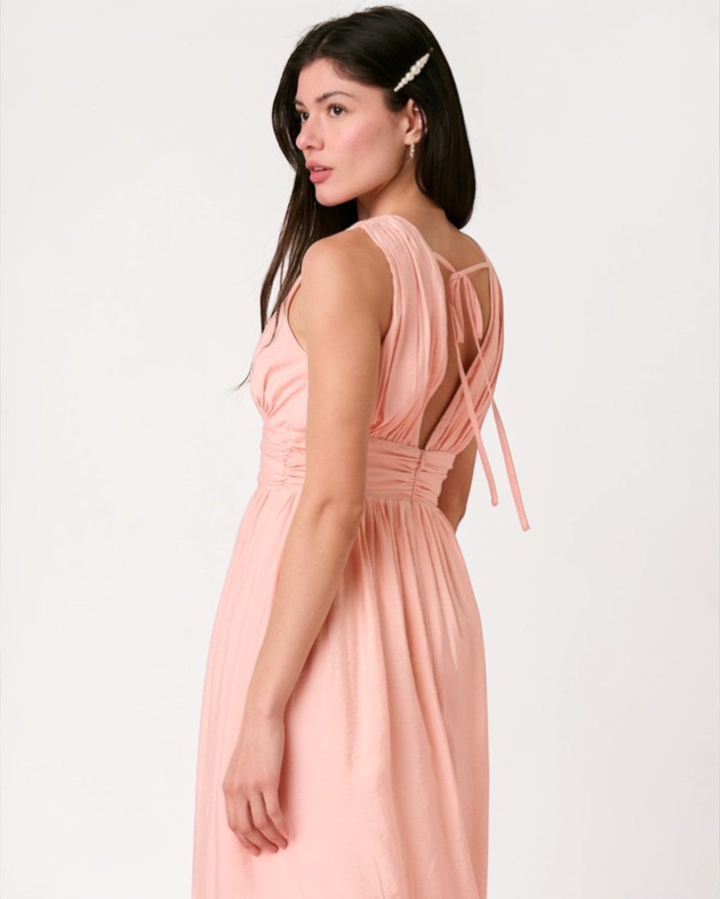 Woman wearing a pink dress with a white background