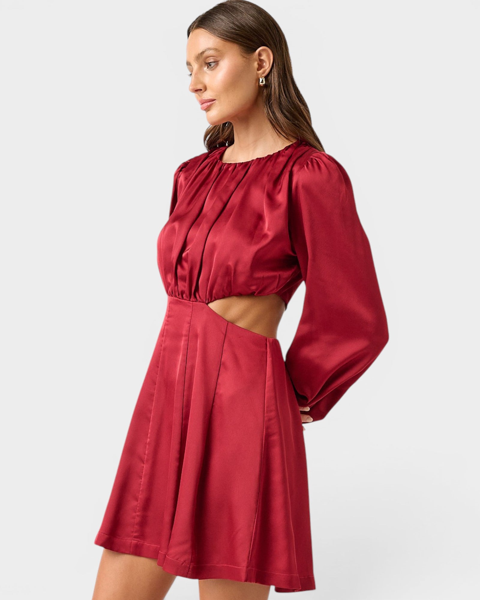 Woman wearing a red dress with cut-out design on a white background