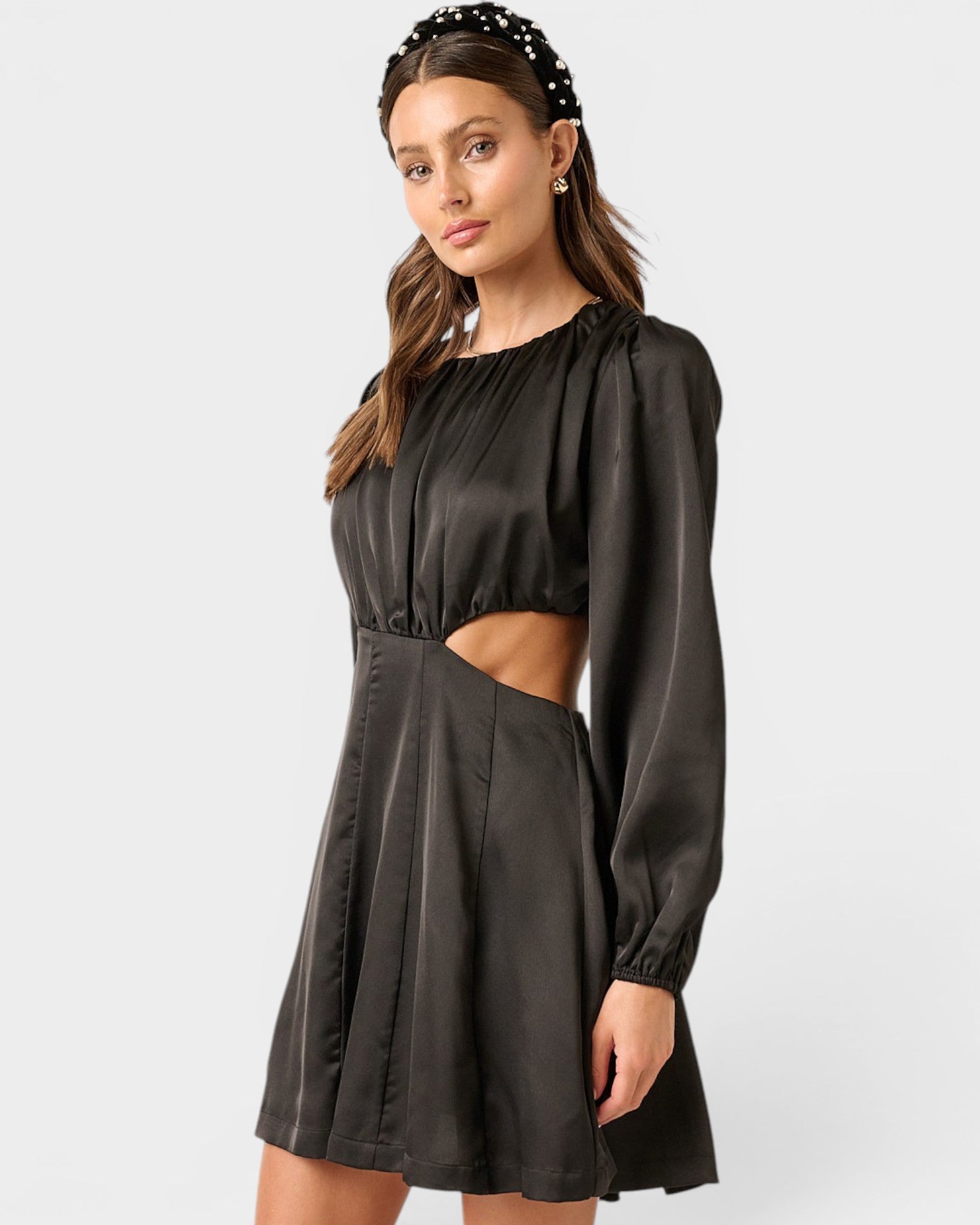 Woman wearing a black dress with cut-out design on a white background