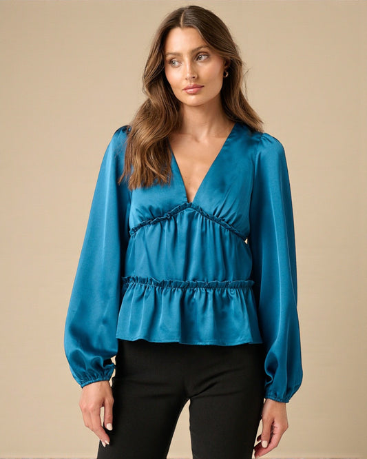 Woman wearing a blue blouse with a beige background