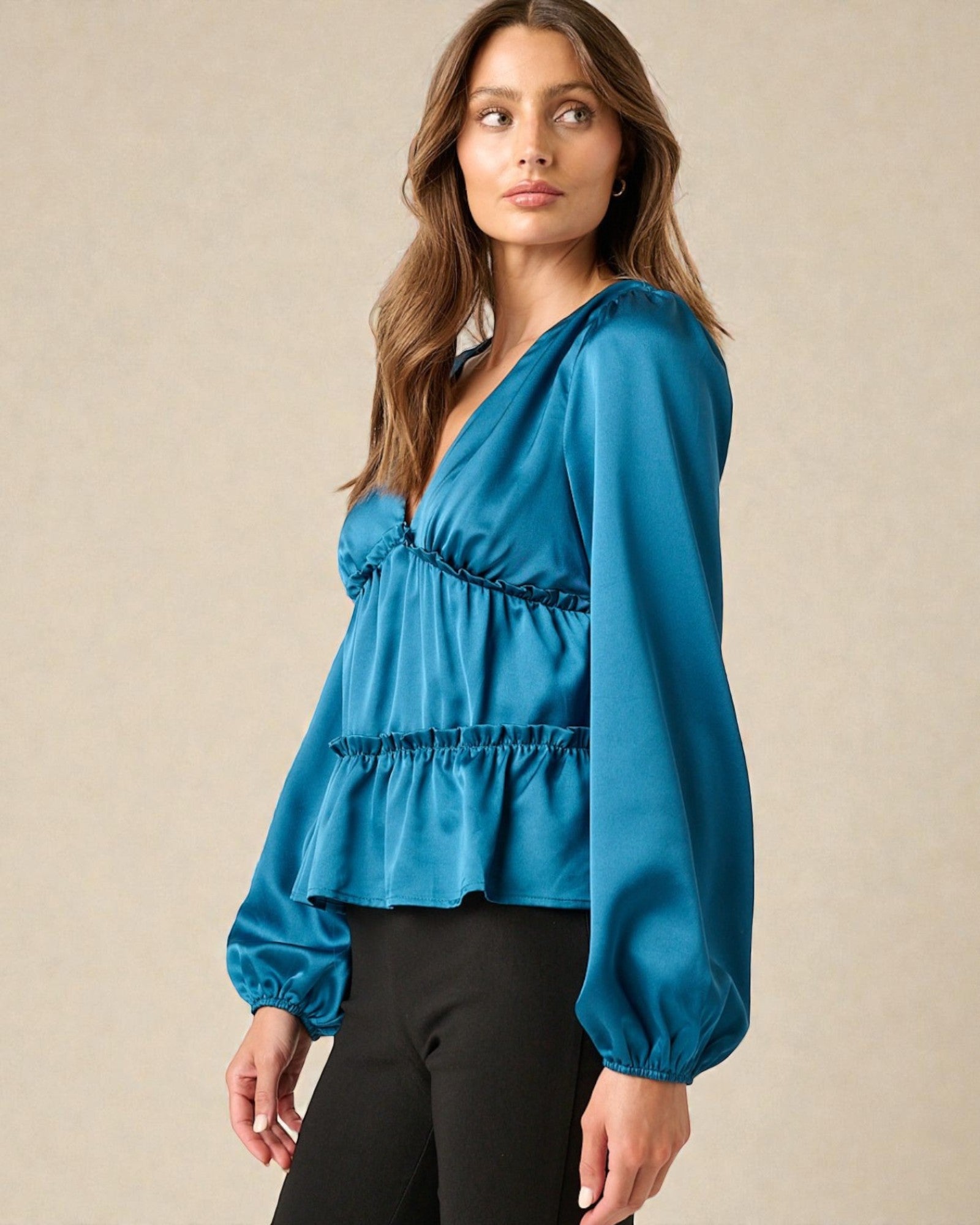 Woman wearing a blue blouse with a plain background