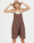 Woman wearing a brown ribbed dress with pockets on a white background