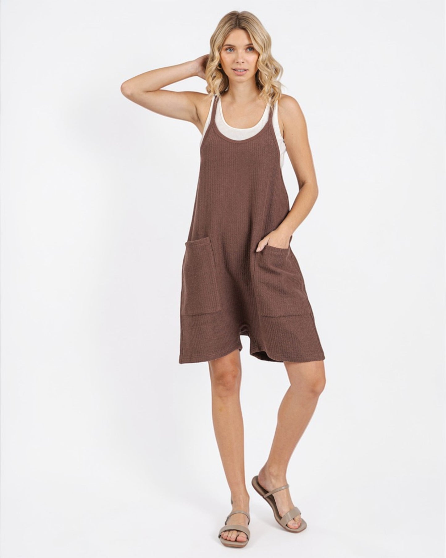 Woman wearing a brown dress with white trim on a white background