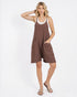 Woman wearing a brown dress with white trim on a white background