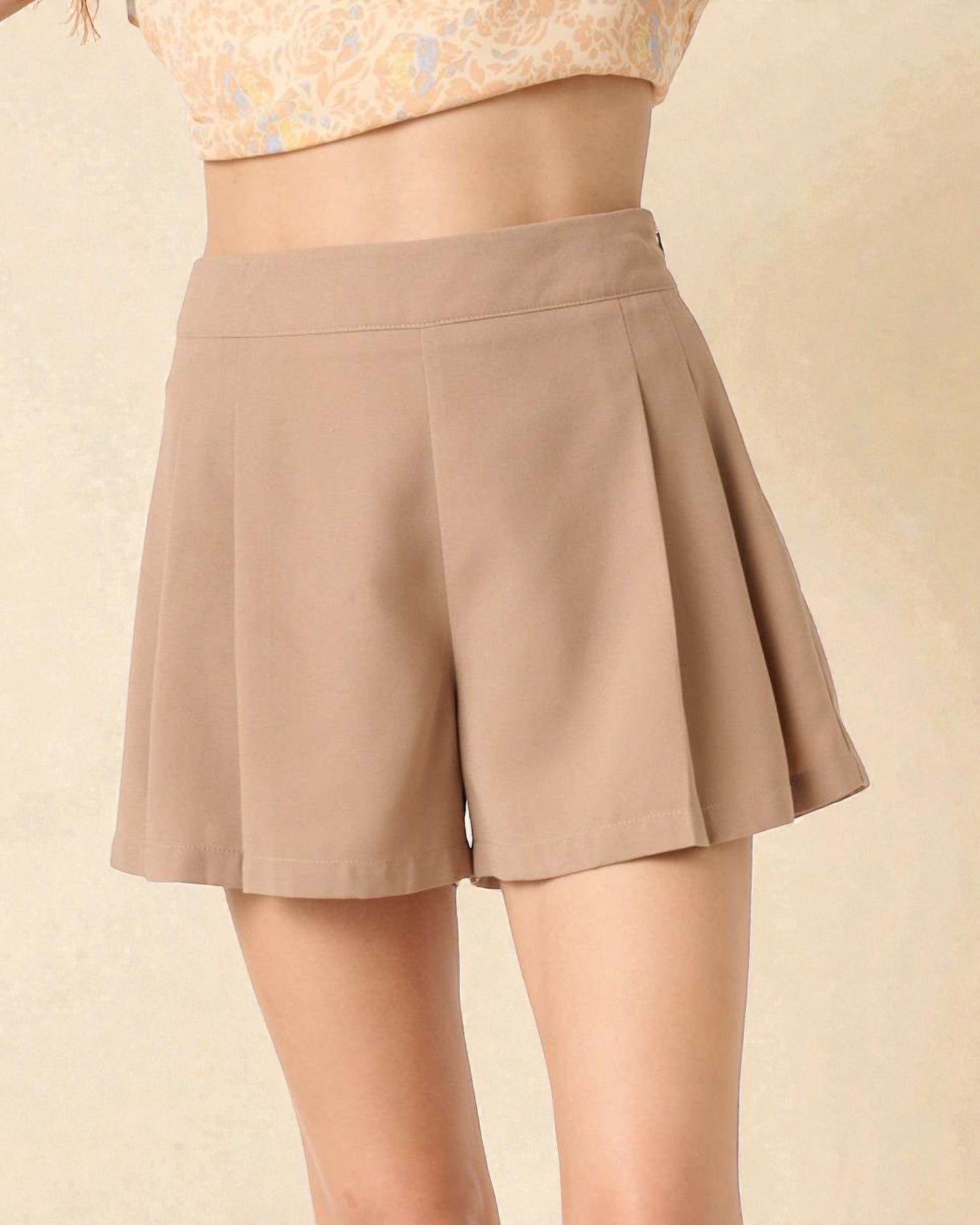 Beige shorts worn by a person on a beige background