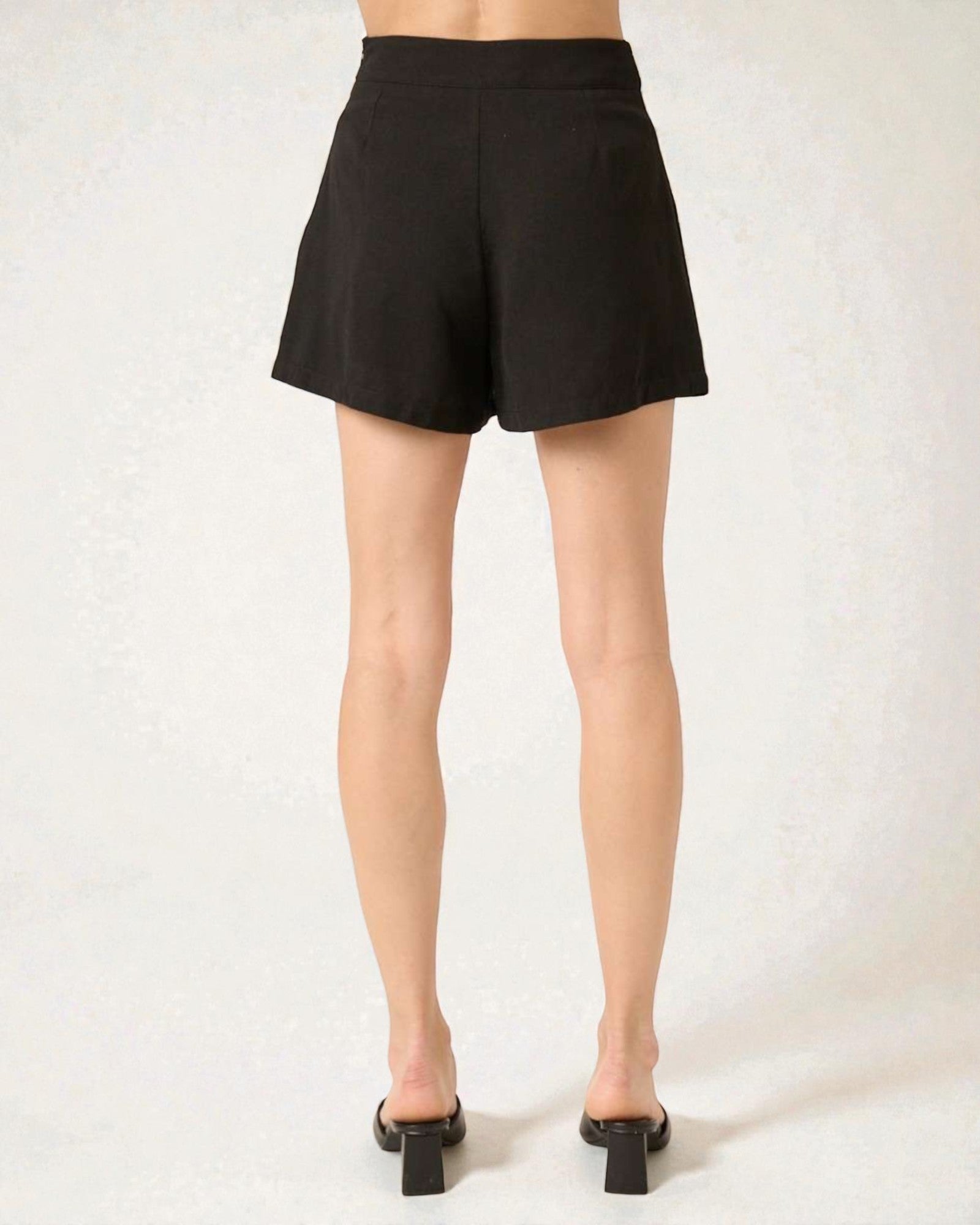 Black shorts worn by a person on a white background